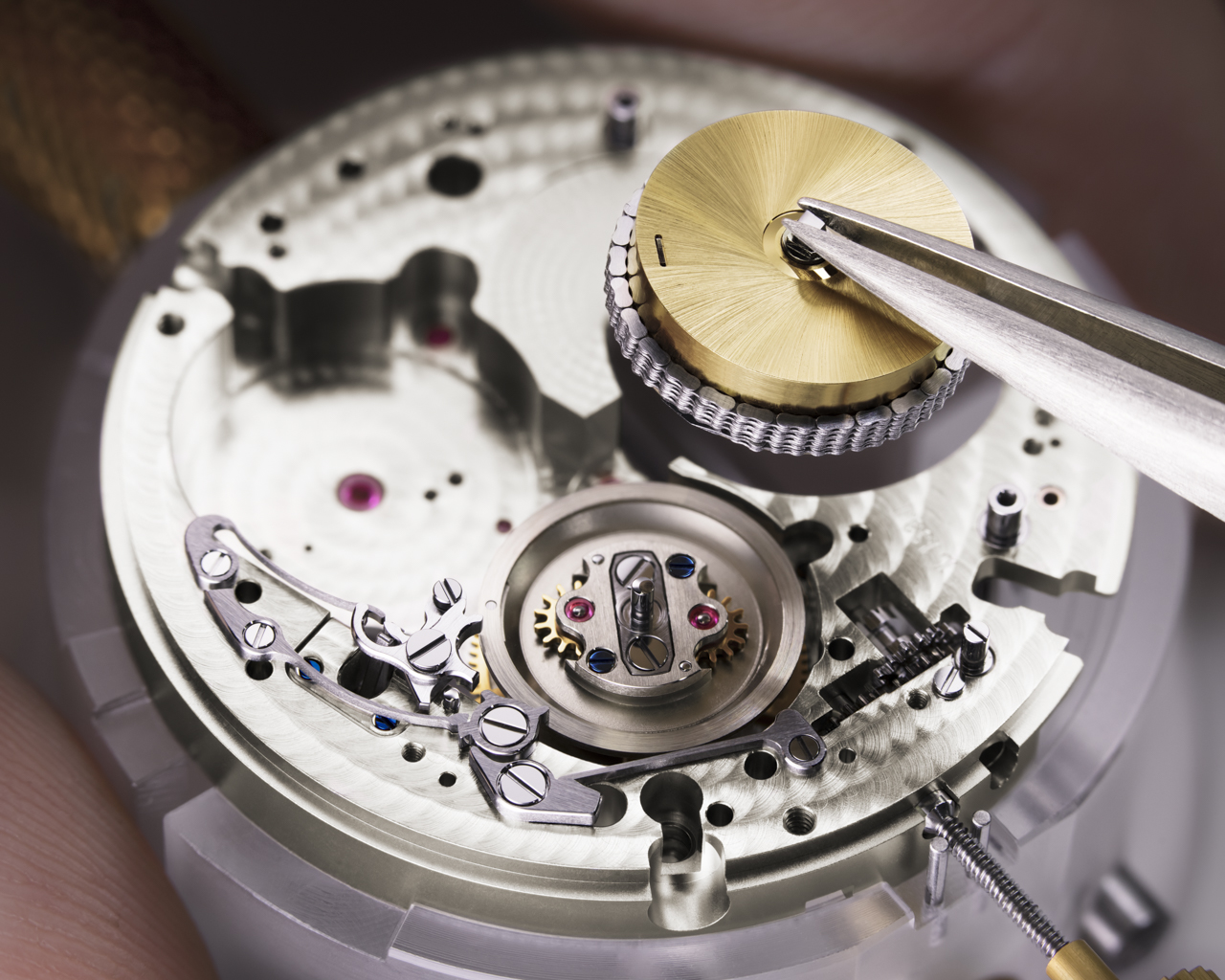 Once the watchmaker has wrapped the delicate chain around the previously assembled mainspring barrel, they can integrate both components into the basic movement. The chain is then attached to the fusée. The planetary gearing or differential must be mounted first.