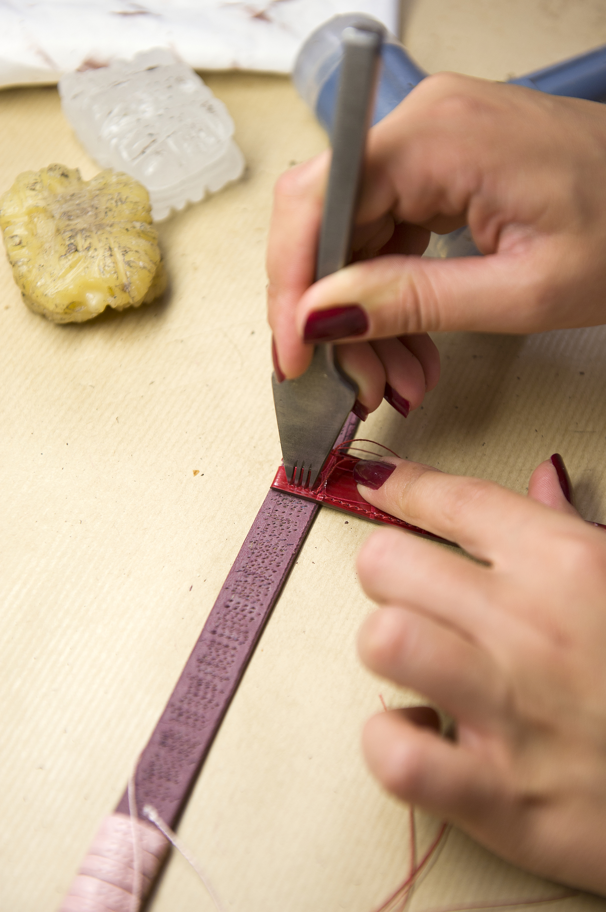 Once the leather is chosen from a delightful array of colours, it is carefully cut and split into three layers. The upper layer is what one sees on the face of the strap, the middle layer is a textile lining and the third layer is what is in contact with the wearer’s wrist. The pre-cut straps are flattened to paper-thickness at their outer edges. A strip of Viledon is placed as a lining between the upper and lower sections of strap, and the whole assembly is glued together. The assembled strap is then sent to the “table workshop” where one artisan hand-stitches, hammers, seals and paints it.